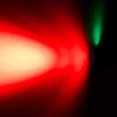 Área escura com luz vermelha grande à esquerda e luz verde pequena à direita