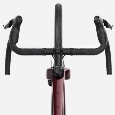 Vista frontal de um guiador e roda dianteira de bicicleta com quadro vermelho e guiador preto.