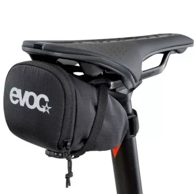 Bolsa de assento preta com logo evoc montada sob selim preto de bicicleta