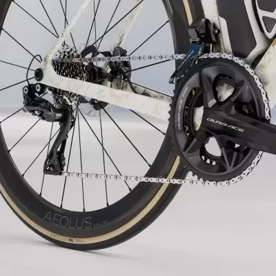 Roda traseira de bicicleta com quadro branco e preto, corrente metálica e pedaleira preta DURA-ACE
