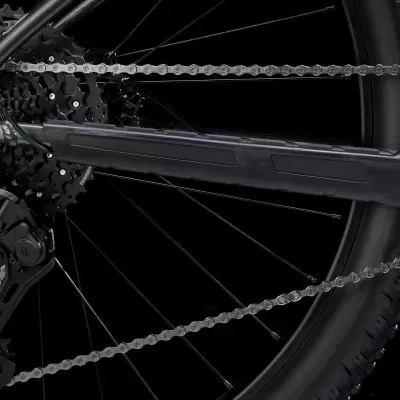 Componentes traseiros de bicicleta preta com corrente e roda sobre fundo preto