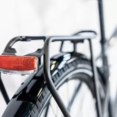 Parte traseira de bicicleta preta com refletor vermelho no porta-bagagens