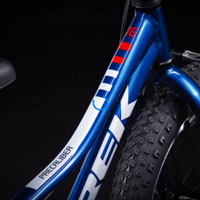 Bicicleta azul metálica TREK com pneus grossos e selo PRECALIBER.