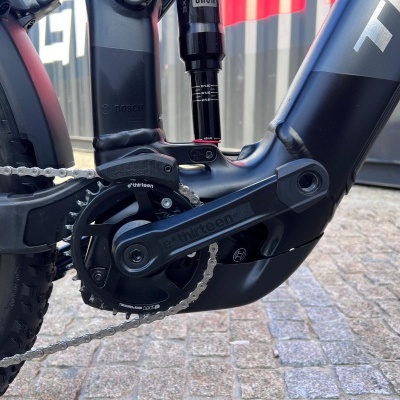 Pedaleiro preto e corrente de bicicleta elétrica com motor Bosch num chão de calçada