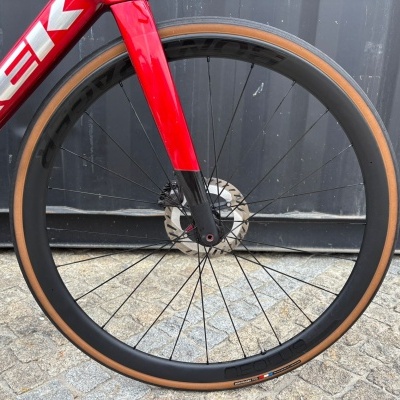 Roda dianteira de bicicleta de estrada com aro preto e pneu castanho