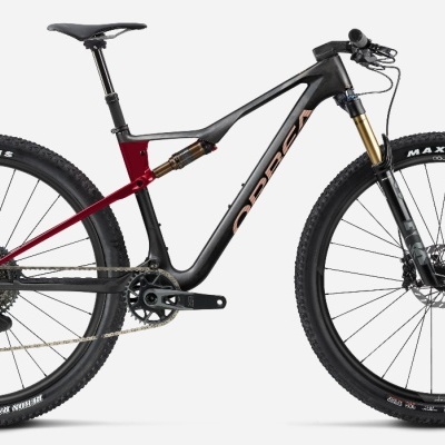 Bicicleta de montanha Orbea preta e vermelha com pneus Maxxis e suspensão dianteira