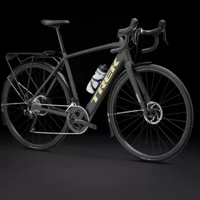 Bicicleta de estrada preta com marca TREK e bagageira traseira