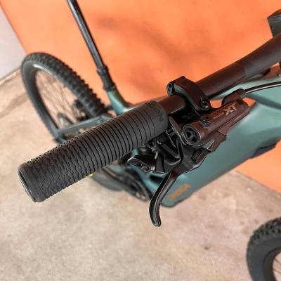 Bicicleta de montanha verde com punho negro e travão Shimano Deore XT