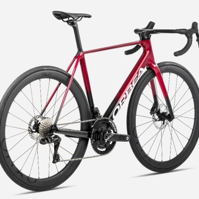 Bicicleta de estrada Orbea vermelha e preta com rodas em carbono