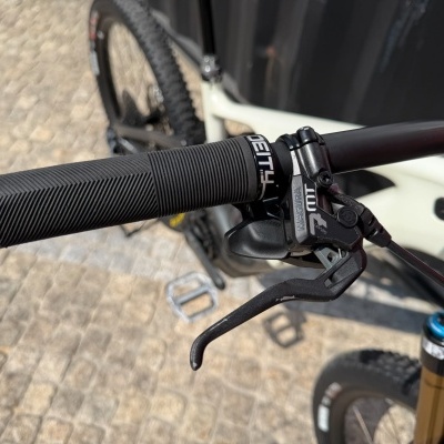 Punho de bicicleta preta com manete de travão e parte da estrutura branca