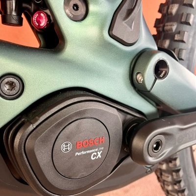 Motor Bosch Performance Line CX preto numa bicicleta verde metálico com roda ao fundo
