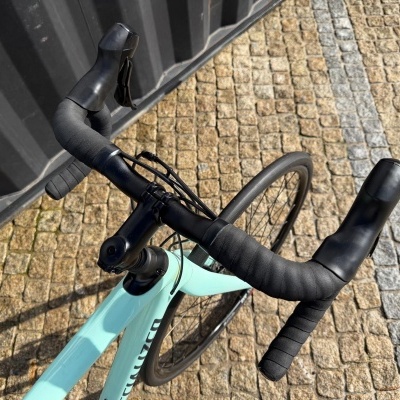 Vista superior de guiador de bicicleta de estrada preta e quadro azul claro com marca SPECIALIZED