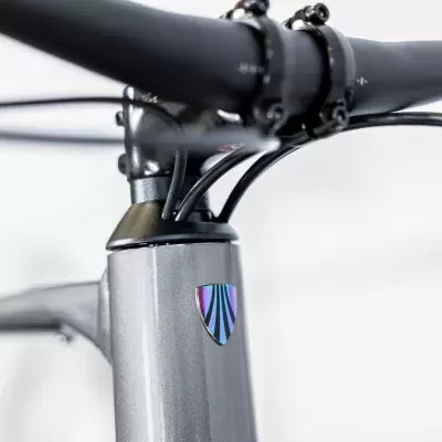 Bicicleta com quadro cinza metálico e autocolante geométrico colorido