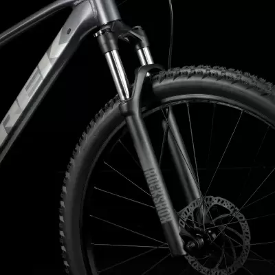 Bicicleta de montanha cinza e preta com suspensão dianteira e disco de travão