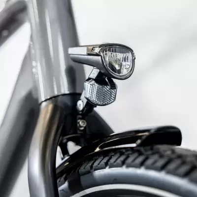 Bicicleta cinzenta com farol dianteiro prateado e pneu dianteiro detalhado