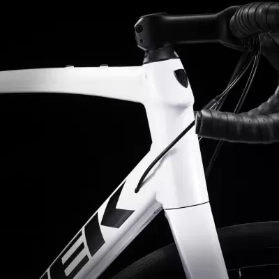 Bicicleta branca com guiador preto em fundo preto