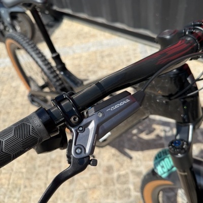 Guiador preto fosco e vermelho de bicicleta com manete SRAM CODE e punho texturizado.