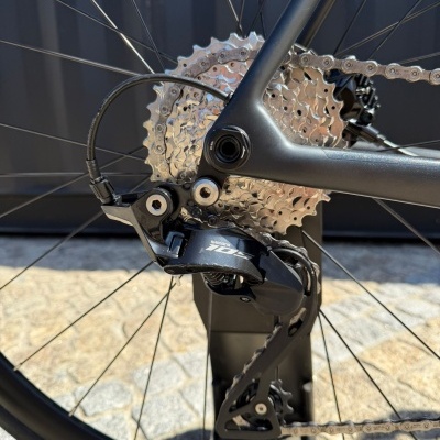 Roda traseira de bicicleta com cassete prateado e desviador SHIMANO 105 preto