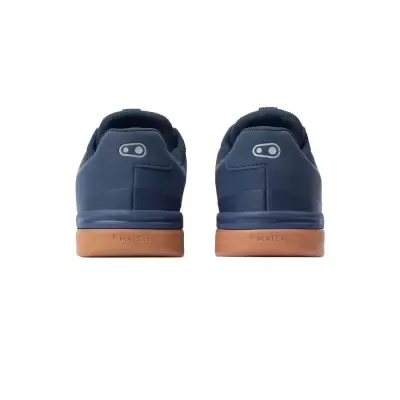 Sapatilhas desportivas azuis com sola castanha vista de trás