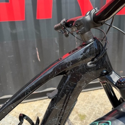 Bicicleta preta com padrão branco e garrafa Rock Shox