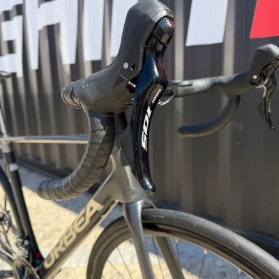 Guiador preto com manípulos de travão Shimano 105 em bicicleta de estrada cinzenta para e-commerce