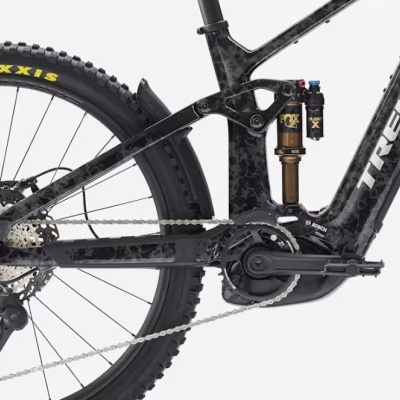 Detalhe da parte traseira e central de bicicleta de montanha elétrica Trek com suspensão Fox e pneu Maxxis