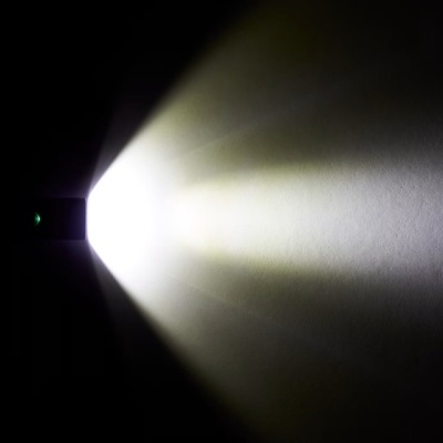 Dispositivo preto montado na parede emitindo luz branca brilhante