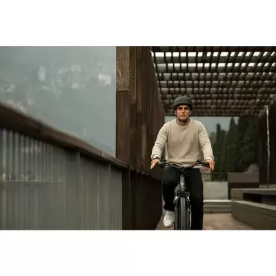 Homem com capacete preto a andar de bicicleta preta numa passarela de madeira