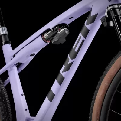 Bicicleta de montanha com quadro roxo, suspensão RockShox e pneus castanhos