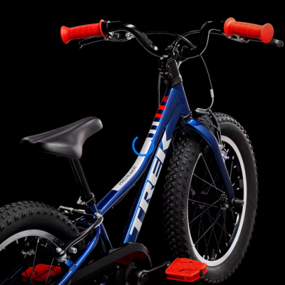 Bicicleta azul TREK com pneus largos e punhos vermelhos em fundo preto
