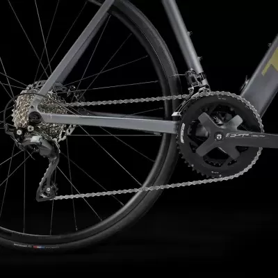 Bicicleta de estrada cinza escuro com transmissão e roda traseira visíveis