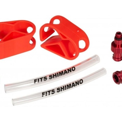 Acessórios para bicicleta, presilhas vermelhas, peças azuis, tubagens transparentes com texto, peças metálicas vermelhas.