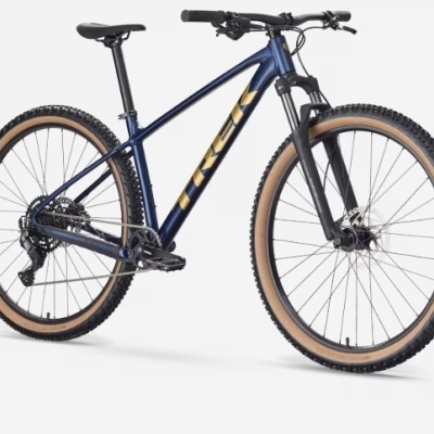 Bicicleta de montanha azul com pneus castanhos e detalhes amarelos