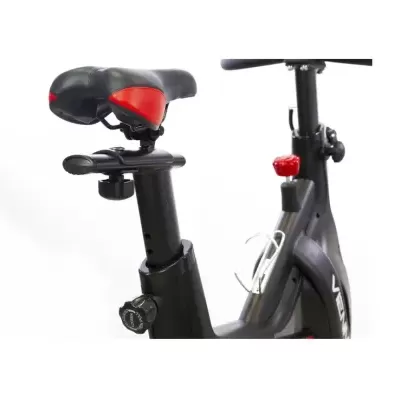 Bicicleta estática preta com assento e detalhes vermelhos