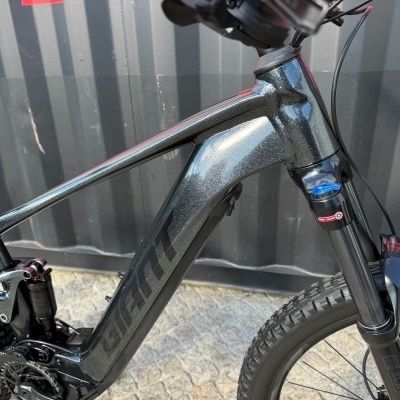 Bicicleta de montanha preta metálica ao ar livre com suspensão dianteira e pneus de cravos