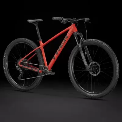 Bicicleta de montanha vermelha e preta com nome TREK exibida em fundo preto