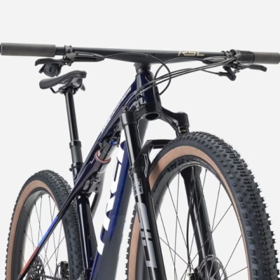 Bicicleta de montanha preta e branca com pneus castanhos e suspensão dianteira