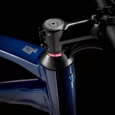 Quadro azul de bicicleta com componentes pretos e detalhe rosa