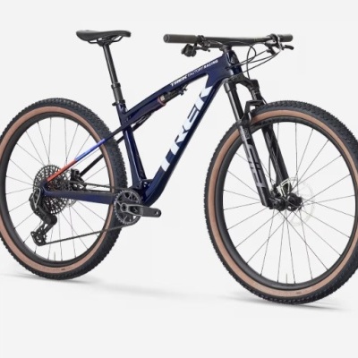 Bicicleta de montanha azul escuro com pneus castanhos e texto KIEN