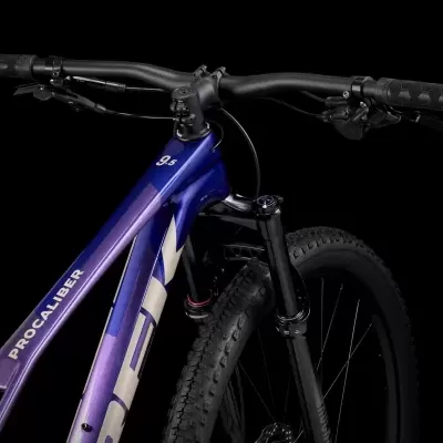 Bicicleta de montanha roxa com suspensão dianteira e guidão preto