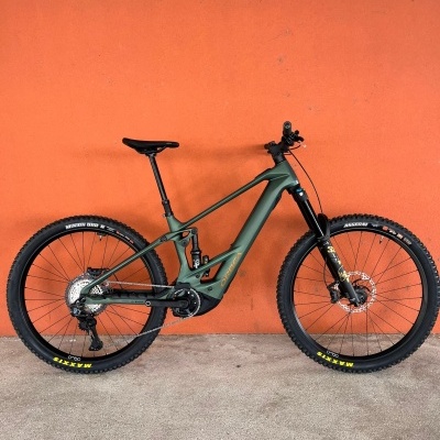 Bicicleta de montanha elétrica Orbea contra parede laranja