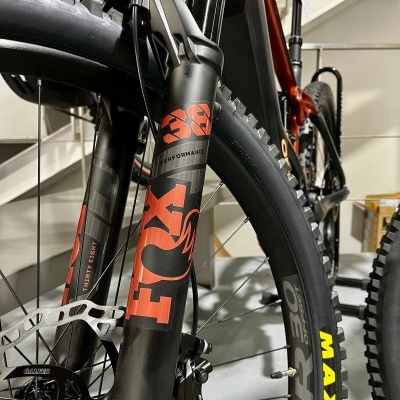 Amortecedor dianteiro FOX 38 Performance e pneus MAXXIS Ardent 3.0 numa bicicleta preta