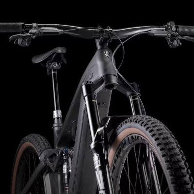 Bicicleta de montanha elétrica preta com pneus largos e suspensão dianteira