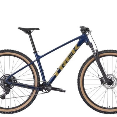 Bicicleta de montanha Trek azul escuro com letras amarelas e pneus castanhos
