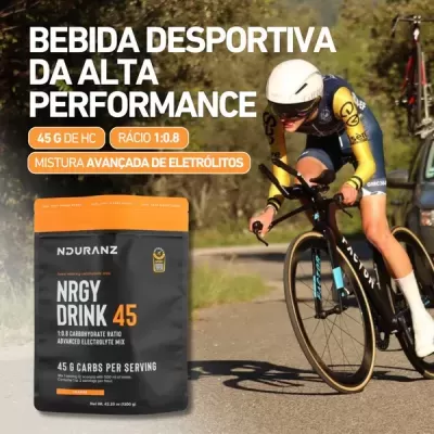 Embalagem de bebida desportiva NRGY DRINK 45 na estrada com ciclista ao fundo
