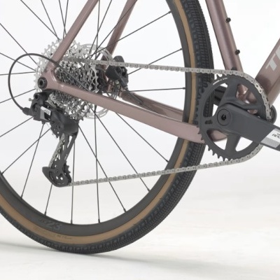 Parte traseira de bicicleta cor rosa com roda preta e pneu castanho