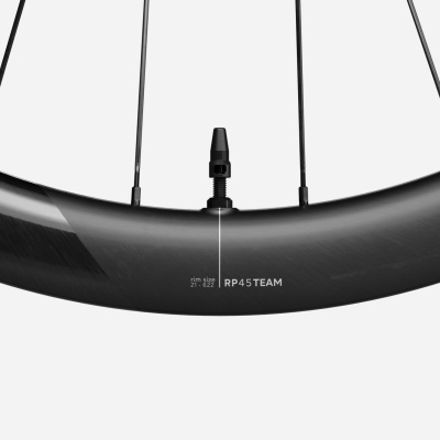 Roda de bicicleta preta em fibra de carbono com válvula e textos no aro.