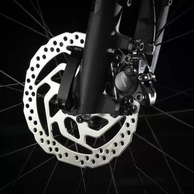 Disco de travão de bicicleta prateado com sistema hidráulico num garfo preto