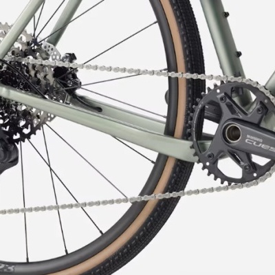 Parte traseira de bicicleta TREK com transmissão Shimano CUE5 e roda com pneu preto e beira bege