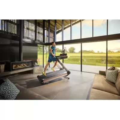 Esteira de corrida moderna em sala de estar com homem a correr